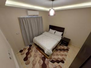 شارع كوين طريق كيلو ٨ في سفاجا: غرفة نوم صغيرة بها سرير وسجادة