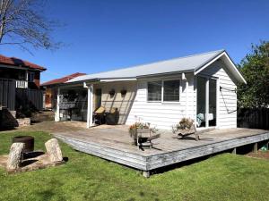 a wooden deck in front of a house at Adorable 1 bedroom guesthouse with firepit in Primbee