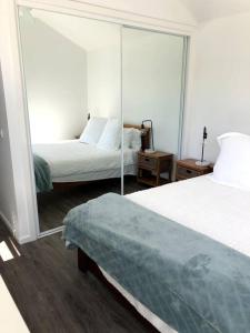 ein Hotelzimmer mit 2 Betten und einem Spiegel in der Unterkunft Adorable 1 bedroom guesthouse with firepit in Primbee