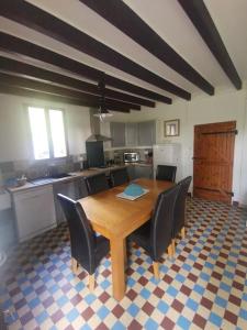a kitchen with a wooden table and black chairs at The Walnut tree. in Saint-Aulaye