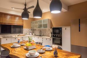 una cocina con una mesa de madera con platos. en 3 Bedrooms sea view villa, en Haad Yao