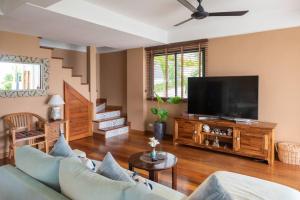 a living room with a couch and a flat screen tv at 3 Bedrooms sea view villa in Haad Yao