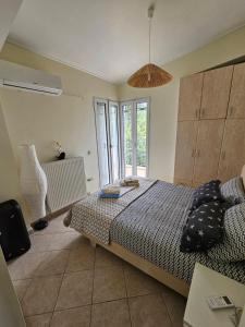 ein Schlafzimmer mit einem Bett und einem großen Fenster in der Unterkunft Villa Zeus in Agios Konstantinos Fthiotida