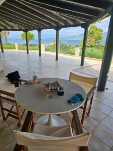 einen Tisch und Stühle mit Meerblick in der Unterkunft Villa Zeus in Agios Konstantinos Fthiotida