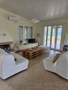 ein Wohnzimmer mit zwei weißen Sofas und einem Sofa in der Unterkunft Villa Zeus in Agios Konstantinos Fthiotida