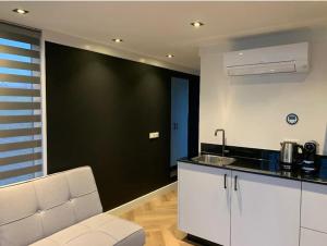 una cocina con una pared negra y un mostrador blanco en Tiny Houseboat Luxery, en Zeewolde
