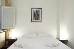 a bedroom with a white bed with two towels on it at Clorinda's rooms in Bari