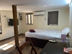 a small room with a bed and a desk and a table at Bella in Mumbai