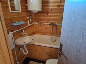 een badkamer met een bad, een wastafel en een toilet bij Kolibe Ćorić in Mojkovac