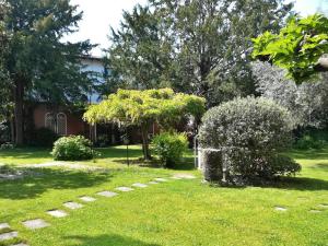 a yard with a house and some bushes and trees at Palazzetto Scodellari in San Vito al Tagliamento