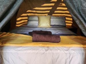 a bed with two towels on top of it at Jackal Cry River View Tent in Skeerpoort