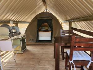 a tent with a table and a bed in it at Jackal Cry River View Tent in Skeerpoort
