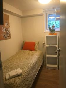 um pequeno quarto com uma cama e uma janela em Spangsbo b&b em Randers