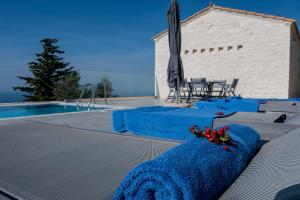 a pool with a blue blanket next to a table and chairs at SAPPHIRE AGIOS NIKITAS in Drymon
