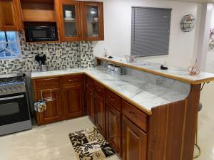 a kitchen with wooden cabinets and white marble counter tops at 1 Bed Apartment - Sleeps 2 - Parking - Wifi in Georgetown