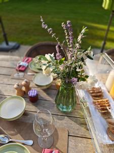 a wooden table with a vase of flowers on it at Mas Sourso in Eygalières