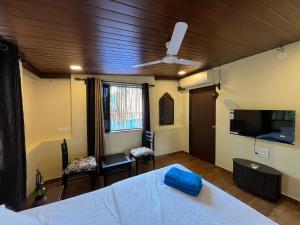 a bedroom with a bed and a ceiling fan at Rocky in Mumbai