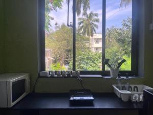 a bathroom with a window with a sink and a television at Rocky in Mumbai