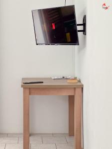 a wooden table with a tv on a wall at Chez Zèlou in Sainte-Anne