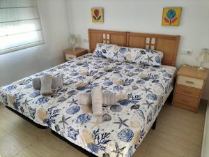 une chambre avec un lit avec une couette bleue et blanche dans l'établissement Denia Holiday Service, à Dénia 58 autres photos
