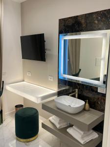 uma casa de banho com um lavatório e um espelho grande em La Lepre Artemide em Nápoles