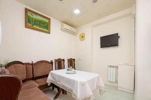 a room with a table and chairs and a tv at Hotel AVE in Yerevan