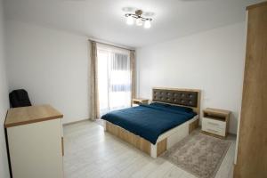 een slaapkamer met een blauw bed en een raam bij DownTown Apartments in Rădăuţi