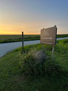 a sign in the grass next to a road at Backadal Gård BnB in Ystad