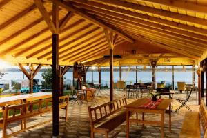 a large wooden pavilion with tables and chairs at Casa de la ghiol in Murighiol