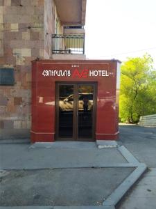 a red building with a hotel sign on it at Hotel AVE in Yerevan