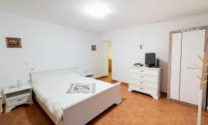 a bedroom with a bed and a dresser and a mirror at Casa de la ghiol in Murighiol