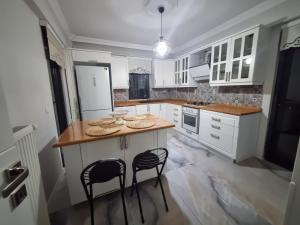 a kitchen with white cabinets and a island with two chairs at Villa Panorama Sapanca in Sapanca