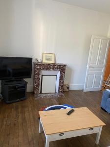 a living room with a coffee table and a tv at Appart Rez de jardin in Dijon