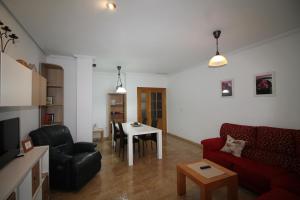 a living room with a red couch and a table at Apartamento BENIMUR 3 in Cobatillas