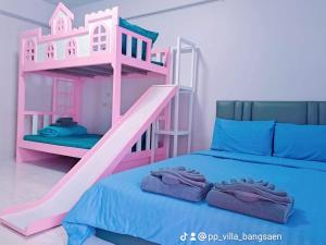 ein rosafarbenes Etagenbett in einem Zimmer mit einem blauen Bett in der Unterkunft พีพี วิลล่า บางแสน รีสอร์ท in Ban Bang Saen (1)