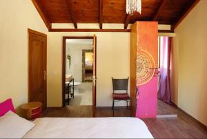 a bedroom with a bed and a chair and a mirror at Finca verde de la luz in Barbate