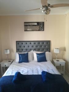 sypialnia z dużym łóżkiem z niebieskimi poduszkami w obiekcie Captain's Sea Cabin w Kapsztadzie