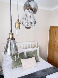 a bedroom with a bed with two chandeliers at Park View in Quorndon