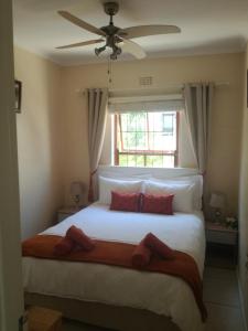 a bedroom with a large white bed with a window at Captain's Sea Cabin in Cape Town