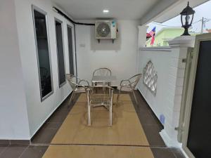 a dining room with a table and chairs on a floor at AliyaRoseMuslim Homestay in Ayer Keroh