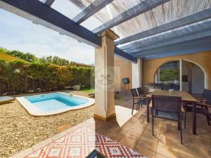 an outdoor patio with a pool and a table and chairs at Villa 4 chambres avec piscine in Fréjus