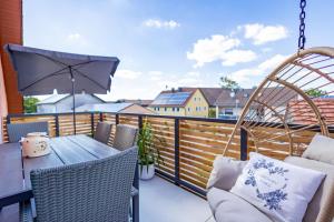 een balkon met een tafel en stoelen en een parasol bij Gasthof Schneiderwirt, Kipfenberg OT Hirnstetten in Kipfenberg