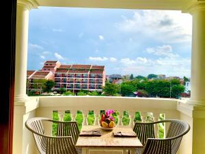 a table and chairs on a balcony with a view of a building at Aman Boutique Hotel in Hoi An