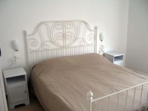 a white bed in a bedroom with two night stands at Apartment with private Garden in Finale Ligure
