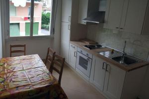 a kitchen with a table and a sink and a stove at Apartment with private Garden in Finale Ligure +8 photos