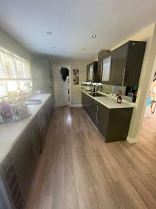 a large kitchen with wooden floors and a kitchen with counters at Home in Wirral - Peaceful Contemporary Gem. in Wirral