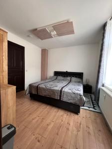 a bedroom with a bed and a wooden floor at Gera Apartment in Gera +11 photos