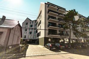 een gebouw waar een auto voor geparkeerd staat bij DownTown Apartments in Rădăuţi