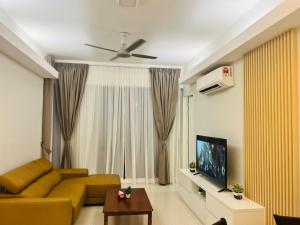 a living room with a yellow couch and a television at Sentral Serviced Suites Kuala Lumpur in Kuala Lumpur