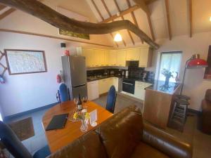 a living room with a table and a kitchen at Seafret Barn sleeps two, North Norfolk in Roughton